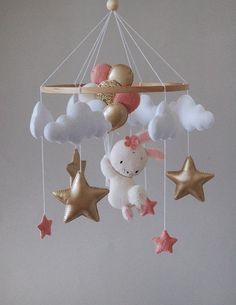 a baby crib mobile with stuffed animals and stars hanging from it's sides