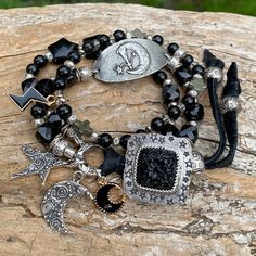 Moody black boho bracelet with a beautiful and unique artisan custom carved black Onyx and hand stamped 925 silver button closure.  6mm round Shungite beads, black Tourmaline 10mm faceted square beads. Very unique artisan pewter Moon Goddess focal bracelet link and Karen Hill Tribe fine silver beads and link. Artisan sterling silver whimsical crescent moon and star charms, black Onyx 15mm star beads, pewter cross beads, enamel crescent moon charm and lightening bolt charm,  3 artisan sterling si Black Moon Charm Jewelry For Festivals, Black Jewelry With Moon Charm For Festivals, Handmade Symbolic Black Beaded Bracelets, Handmade Symbolic Black Bracelets, Black Moon Phase Jewelry For Festivals, Handmade Onyx Black Bracelets, Handmade Black Onyx Bracelets, Adjustable Bohemian Beaded Bracelets With Moon Charm, Adjustable Black Festival Jewelry