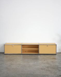 the sideboard is yellow and has two open shelves on each side, with one door closed