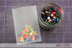 a jar filled with lots of different colored candies on top of a cutting board