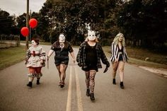 three women in costumes are walking down the street with clowns on their heads and legs