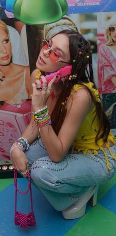 a woman sitting on top of a toilet holding a pink phone to her ear and looking at the camera