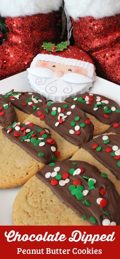 chocolate dipped peanut butter cookies on a plate with santa clause in the background and christmas decorations