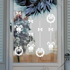 the window is decorated with white flowers and ribbons on it's side door sill