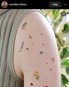 the back of a woman's arm with small flowers on it