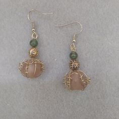 Frosted, translucent baroque soft pumpkin orange beads caged with gold wire tendrils. They fall below an intricately molded gold bead that is topped by a small green glass bead that catches light with its subtle sparkly swirls.  I think they would be perfect for an enchanted evening in October! Gold Aventurine Beaded Jewelry, Amber Wire Wrapped Drop Earrings, Bronze Wire Wrapped Czech Glass Earrings, Bronze Wire Wrapped Earrings With Czech Glass, Gold Bohemian Wire Jewelry, Bohemian Gold Wire Jewelry, Gold Aventurine Earrings Gift, Bohemian Orange Wire Wrapped Jewelry, Gold Spiritual Beaded Earrings For Gifts