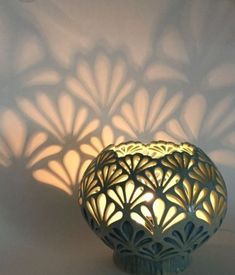 the shadow of a vase is cast onto the wall with it's lights on