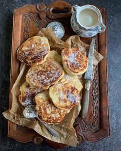 some food is sitting on a tray next to a cup of coffee and a spoon