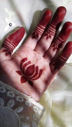 a woman's hand with red henna on it