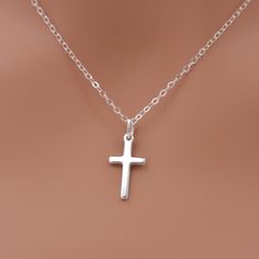 This beautiful piece is made of solid sterling silver for a lasting keepsake. Features a cross in a small 3/4 inch size, set on a sterling silver chain that closes with an easy-to-use spring ring clasp. Comes in a little gift box.  SEND AS A GIFT: You can send this gift directly to the recipient, along with your personalized note. Just select "this is a gift" and leave your note. Be sure to update the address (to your recipient's) when ordering.  SIZING - PLEASE READ: Please note that necklaces will fit differently depending on a person's size. I recommend measuring to be safe. Please note that my jewelry is not intended for anyone 12 years of age or younger. Note that small pieces of jewelry (or if the jewelry becomes broken) is a choking hazard for children and should not be used around Classic Sterling Silver Crucifix Necklace, Classic Cross Pendant Necklace As Gift, Casual Silver Hypoallergenic Cross Pendant Jewelry, Hypoallergenic Silver Cross Pendant Jewelry, Classic Sterling Silver Cross Charm, Sterling Silver Cross Charm Necklace, Sterling Silver Cross Jewelry With Clasp, Sterling Silver White Gold Necklace For First Communion, Sterling Silver Cross Necklace For First Communion