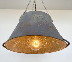 a metal light hanging from a ceiling with chains around it and stars on the bottom