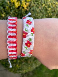 a close up of a person's arm wearing two bracelets with flowers on them