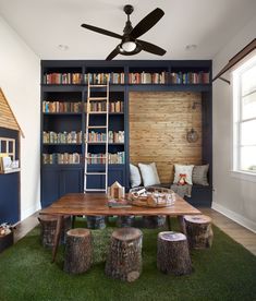 a living room filled with furniture and bookshelves next to a green area rug