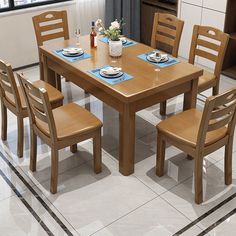 a kitchen table with four chairs and plates on it