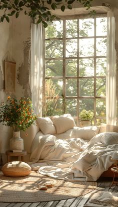 an unmade bed with white sheets and pillows in front of a large open window