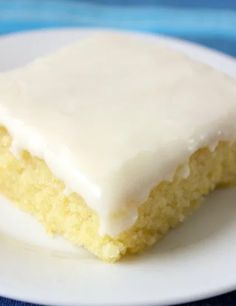 a close up of a piece of cake on a plate with white frosted icing