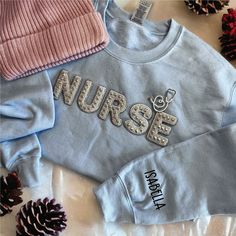 Custom Nurse Sweatshirt with  Name on the Sleeve and Stethoscope Brooch  IMPORTANT NOTE Please make sure to CHECK YOUR Email Or your Etsy Conversations after you placed an order until you receive your package in case we have a question regarding your order! The use of the messaging system is very easy and convenient and you can always expect a timely reply during business days/hours. We are not responsible for packages that do not make it in time of your event if you did not give us a "Date Need Nurse Sweatshirt Ideas, Nurse Graduation Cap Designs, Nurse Gear, Nursing Motivation, Nursing Pins, Christmas Gifts For Nurses, Nursing School Tips, Nursing Accessories, Graduation Cap Designs