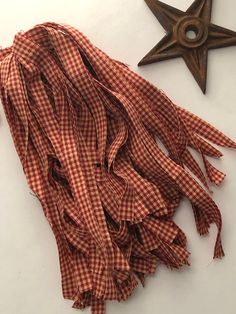 a red and white checkered scarf next to an old star