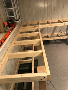 the inside of a storage room with wooden shelves and tools on the floor next to it