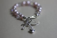 "Perfect Keepsake bracelet that is handmade and custom designed for you. ♥ Swarovski Crystal Pearls, Sterling Silver grow with me extension chain, Sterling Silver monogram charm disc, Sterling Silver cross charm.  The bracelet is handmade with high quality 6mm Swarovski Crystal pearls, 6mm Swarovski clear Crystals , a one-inch STERLING SILVER \"Grow-With-Me\" extender chain which features a gorgeous STERLING SILVER heart, a Sterling Silver cross  smooth cross charm. Approx size: 16mm L x 11mm W x 1mm T and finished with a Sterling Silver 12mm hand stamped Monogram Charm to personalize your bracelet.  PLEASE LET ME KNOW IF YOU NEED A RUSH ON YOUR ORDER. Message me to see if I can rush your order and have it out sooner.  You will not be disappointed! It will arrive in a beautiful gift bag or Handmade Round Charm Bracelet For Birthday, Handmade Name Bracelet For Personalized Gifts, Handmade Round Name Bracelet For Birthday, Handmade Charm Bracelet For Personalized Gifts, Handmade Charm Bracelet As Personalized Gift, Handmade Round Beads Jewelry For First Communion, Personalized Rosary Bracelet Gift, Handmade Silver Jewelry For Baptism, Personalized Round Rosary Bracelet Gift