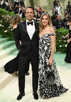 a man and woman standing next to each other in front of photographers at an event