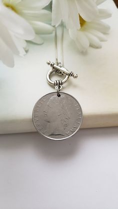 "Celebrate your Italian heritage with this necklace or gift it to a lover of Italy! It is made from a 1982 100-lira Italian coin that dangles from a 16\" snake chain with a front toggle closure. The coin is 1\" in diameter. Welcome to Recycled Finery!  I repurpose old jewelry, coins, beads, vintage buttons, watch parts, and charms into new jewelry.  My ever-growing collection of these materials comes from estate sales, rummage sales, antique and thrift stores, and family and friends' collections Classic Medallion Necklaces With Charms, Gift Medallion Necklace With Vintage Charm, Vintage Charm Medallion Necklace Gift, Round Medallion Necklace With Vintage Charm As A Gift, Anniversary Coin Pendant Jewelry, Anniversary Gift Coin Pendant Jewelry, Heirloom Necklaces With Charms, Heirloom Round Charm Necklaces, Commemorative Coin Pendant Medallion Jewelry