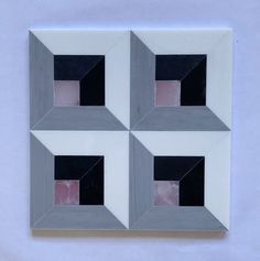 four squares are arranged in the shape of rectangles on a white surface with black and pink areas