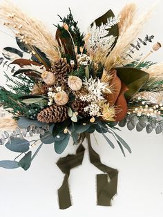 an arrangement of flowers and foliage on a white background