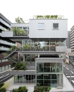 an apartment building with many windows and plants on the top floor, along with several balconies