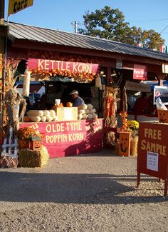 an outdoor market with pumpkins and hay for sale