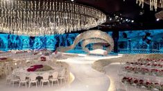 an elaborately decorated banquet room with chandeliers and white tablecloths on the tables