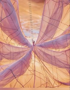 a person standing on a ladder in the middle of a large white sheet with pink fabric covering it