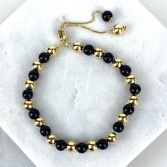 "18k Gold Filled 1mm Box Chain Bracelet Featuring Simulated Onyx Black Bead Ball, Gold Beads, Adjustable Bracelet - Bracelet Size: Thickness: 0.9 mm | Beads Width: 5.8 mm | Length: 9 Inches 💎 With new products daily, quality and competitive prices, in DiJu Jewelry you find the most unique styles of modern designs, always looking for elegance and market trends. *Helping your Jewelry Businesses Grow *Starting your Own Business *Making your Own Collection: DiJu Jewelry ever brings Better Moments f Luxury Classic Black Gold Bracelet, Adjustable Gold Beaded Bracelets With Gemstone, Elegant Black Rosary Bracelet With Round Beads, Black Bracelet With Gold Beads, Adjustable Onyx Beaded Bracelets With Polished Beads, Adjustable Gold Onyx Bracelets, Adjustable Gold Onyx Bracelet, Adjustable Black Bracelets With Gold Beads, Adjustable Onyx Jewelry With Black Beads