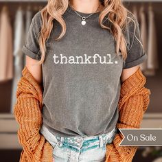 Searching for a minimalist, original, and comfy shirt that will express your overwhelming excitement for Thanksgiving season? Look no further than our "thankful. Comfort Colors Shirt"! This comfortable and stylish shirt is perfect for outdoor activities or relaxing at home. This shirt is sure to keep you cool and comfortable all season long with it's double-needle stitching throughout which makes it highly durable while the lack of side-seams helps the shirt retain its tubular shape.  This origi Everyday Fall T-shirt With Letter Print, Everyday Cotton T-shirt For Fall, Everyday Fall Slogan T-shirt, Fall Everyday T-shirt With Screen Print, Gray Text Print T-shirt For Fall, Relaxed Fit T-shirt For Everyday Fall, Gray Relaxed Fit T-shirt For Fall, Fall Soft-washed Relaxed Fit Shirt, Soft-washed Relaxed Fit Shirt For Fall