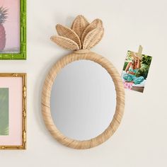 there is a mirror and pictures on the wall next to each other with pineapples