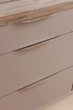 a wooden counter top sitting next to a white wall