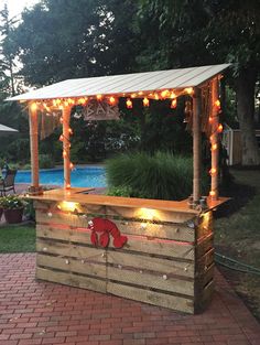 an outdoor bar with lights on it and a red teddy bear painted on the side