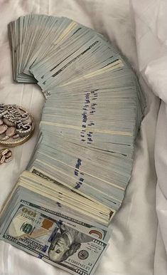 a pile of money sitting on top of a bed