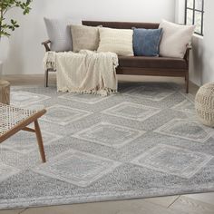 a living room with a couch, chair and rug on the floor in front of a window