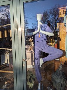 there is a mannequin in the window with its legs crossed and eyes closed