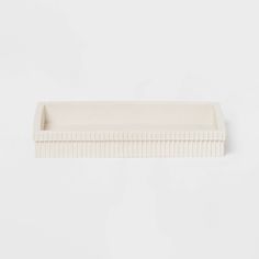 a white rectangular tray with lines on the bottom and sides, set against a plain background