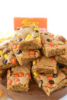 a wooden platter filled with halloween brownies and candy cornflakes on top of it