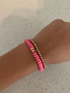 a woman's arm with pink and gold bracelets