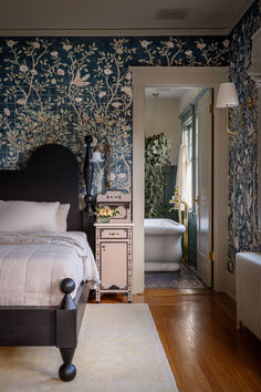 a bedroom with a bed, dresser and bathtub next to a doorway that leads to a bathroom