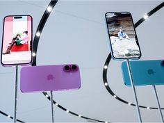 three iphones are displayed in front of a circular display with lights on the sides