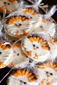 some cookies with orange and white frosting are wrapped in plastic