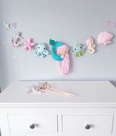 there are many sea creatures hanging on the wall above the table and in front of them is a toothbrush holder