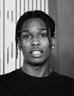 a black and white photo of a woman with dreadlocks on her head looking at the camera