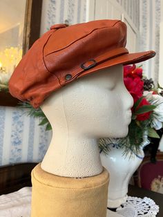 This very cool cap is made of soft leather in rusty brown. It has a small brim with a buckle detail, elastic in the back, and it's fully lined with black fabric lining. Fits men's size small to medium or women's medium to large (the mannequin's head is 19 1/2 inches around). Please note there is a bit of wear on the brim; otherwise, the hat is in good condition. Vintage Leather Hats For Outdoors, Distressed Brown Leather Brimmed Hat, Vintage Leather Hat With Short Brim, Retro Brown Beret For Fall, Vintage Leather Brimmed Hat, Vintage Brown Leather Brimmed Hat, Brown Retro Beret For Fall, Leather Flat Cap Hat For Fall, Leather Flat Cap For Fall