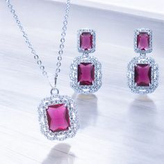 Rhodium Plated Simulated Ruby Cubic Zirconia Pendant Necklace Earrings Set. Necklace Detail: 17"inches with 2"inch extended  Lobster Clasp. Pendant Detail: Width 0.6" Height with Bale 1" Earring Detail: Width 0.6" Height 1" Drop Stud Earrings. Environmental Standard: Nickel-free,  100% Brand New and High Quality. Comes with an elegant gift box. Necklace Earring Set, Elegant Gift, Necklace Earrings, Earrings Set, Rhodium Plated, Earring Set, Jewelry Sets, Cubic Zirconia, Wedding Gifts